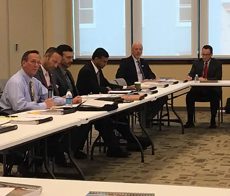 Please at a table reviewing documents.